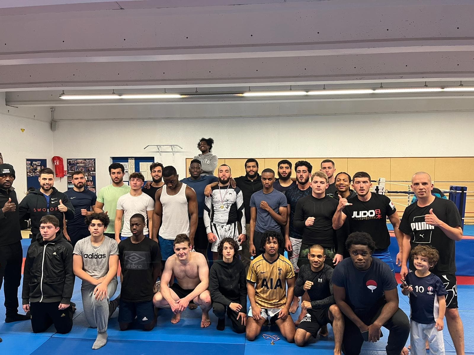 Photo de groupe des adhérents adultes après un entraînement, dans la salle du club.